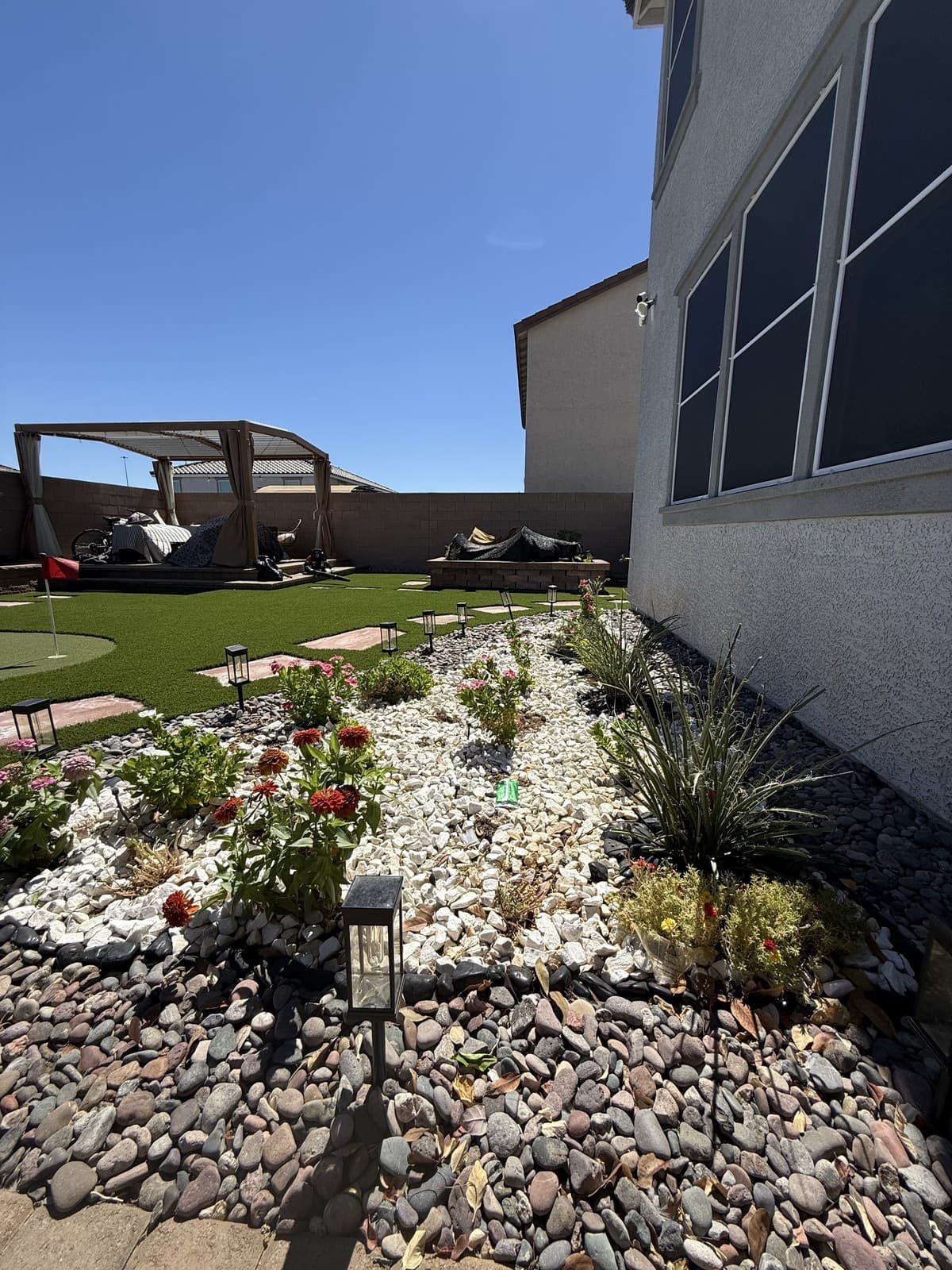 A gravel planting bed with flowering perennials and landscape lighting, Las Vegas